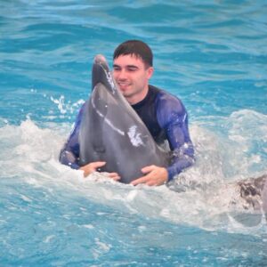 Guest swimming with a dolphin at Dolphins Bay Phuket