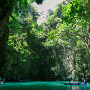 Canoes under the jungle cliffs of a hong