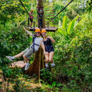 Two riders on a dual zipline