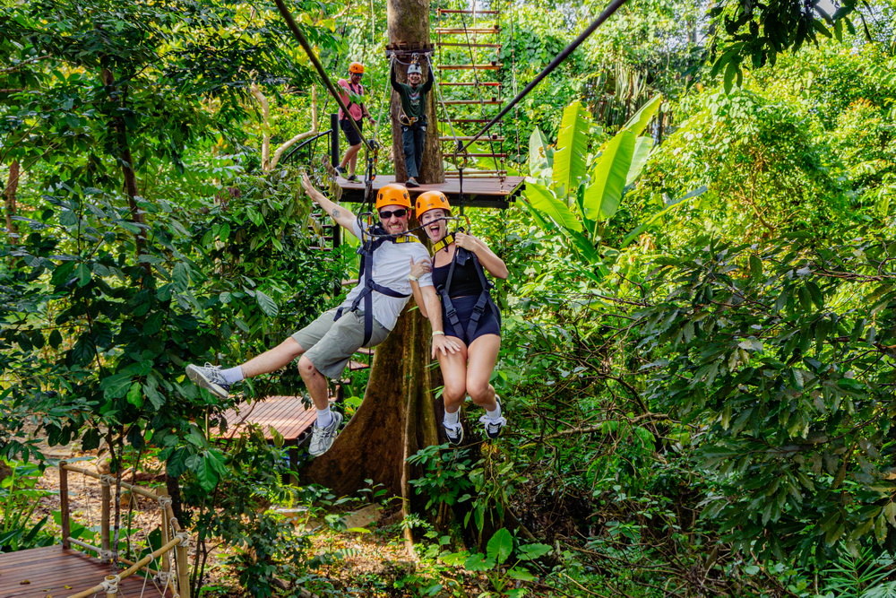 Two riders on a dual zipline
