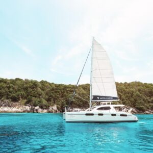 Sailing catamaran off an island beach