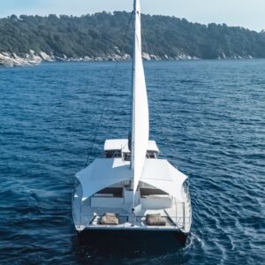 The yacht at anchor off a green island