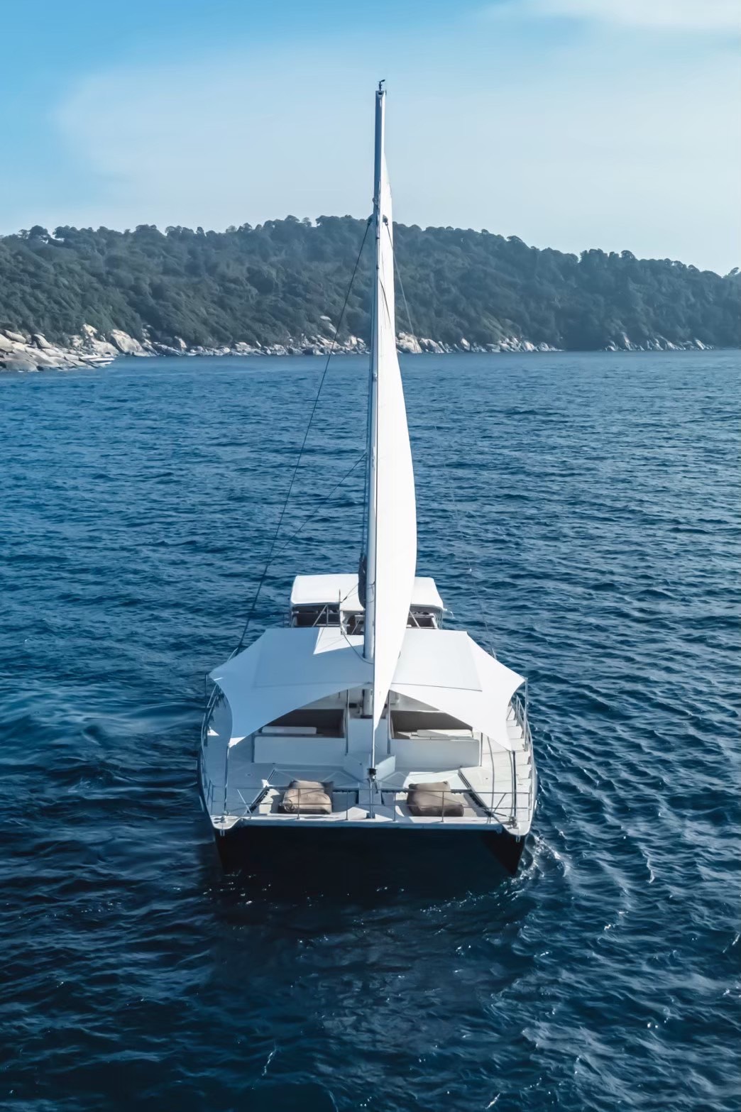 The yacht at anchor off a green island