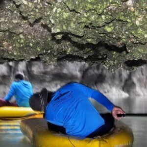 Guide paddling guests under a cave roof