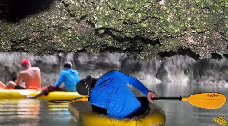 Guide paddling guests under a cave roof