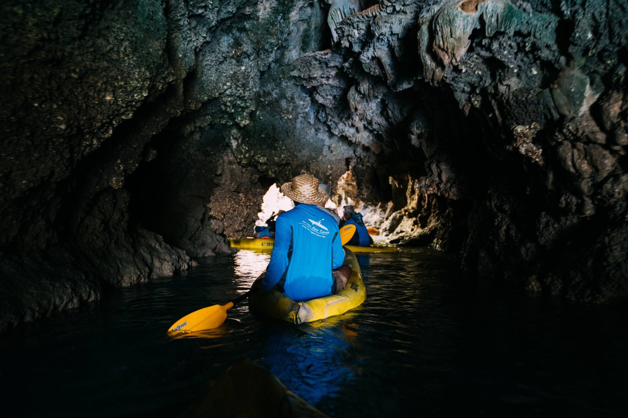 Guide paddling a guest through a dark cave