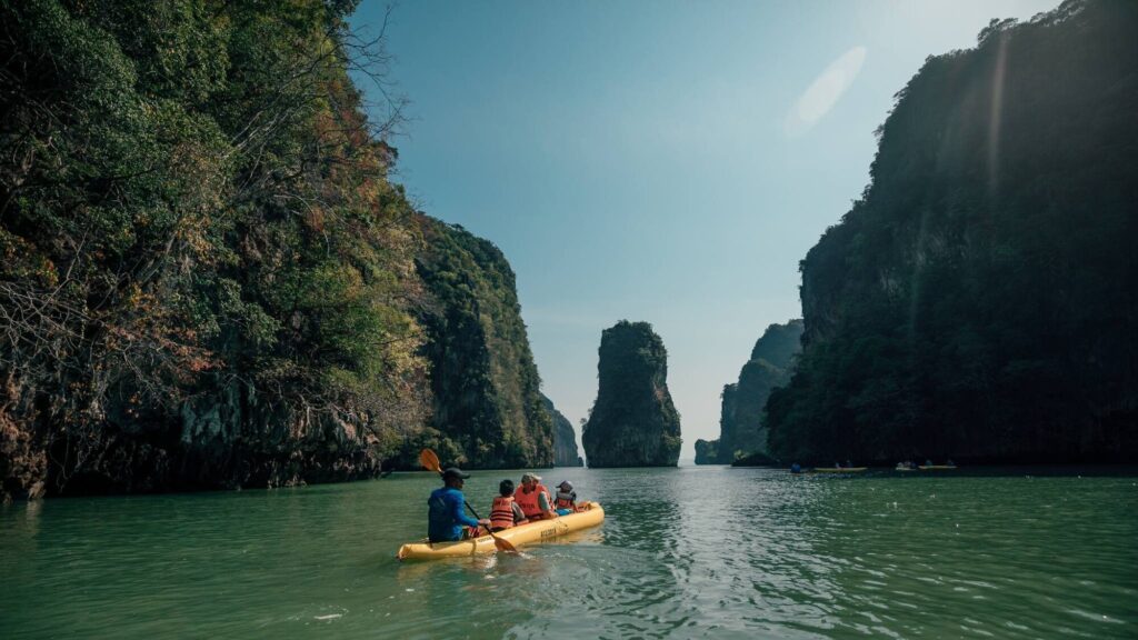 Sea kayaks paddling between limestone karsts in Phang Nga Bay