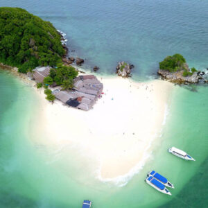 White sandbar at Khai Island with speedboats moored