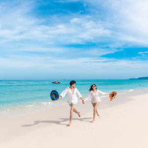 Couple walking hand in hand on a white sand beach in the Phi Phi Islands