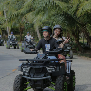 ATV riders on a palm-lined road