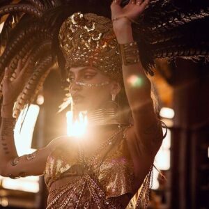 Performer in a feathered headdress at sunset