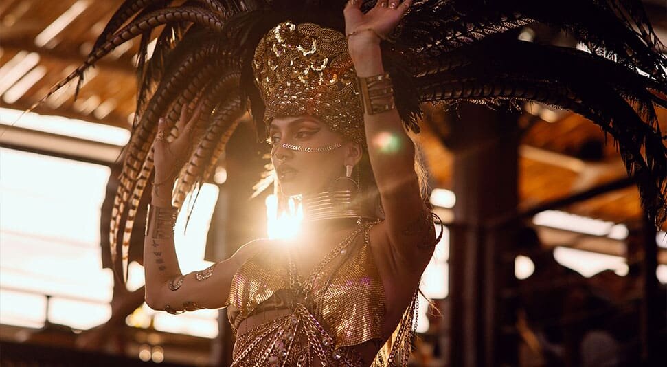 Performer in a feathered headdress at sunset