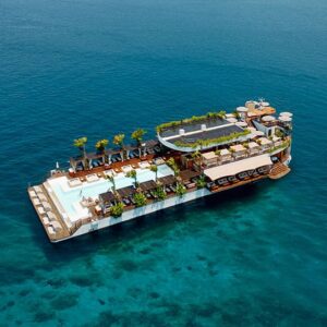 Floating beach club with pool and palm trees out at sea
