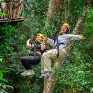 Two riders on a zipline in the Kathu rainforest, Phuket