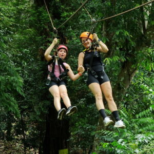 Two guests ziplining side by side