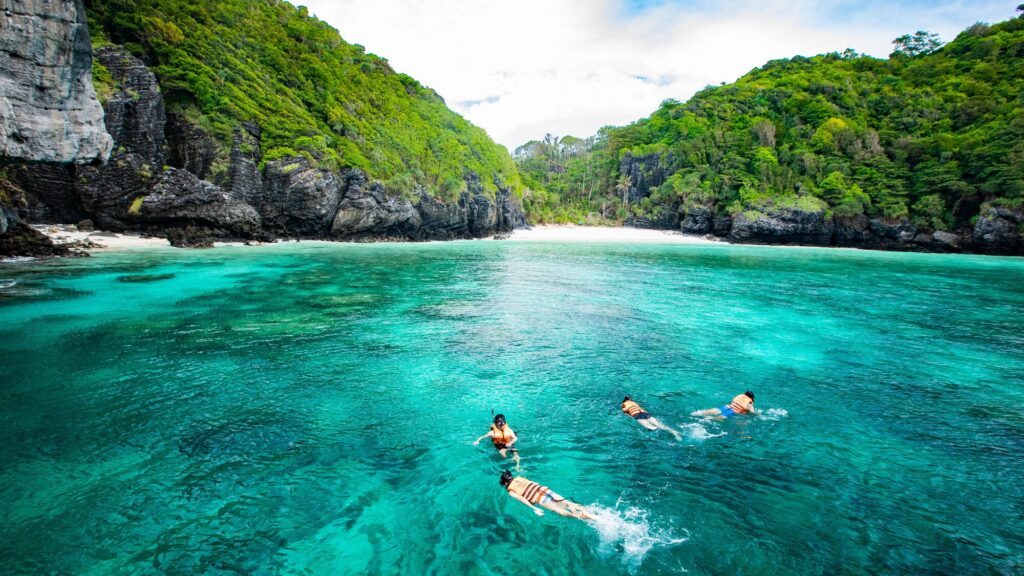 Snorkellers in the emerald water of Pileh Lagoon