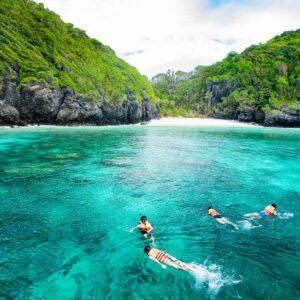 Snorkellers in the emerald water of Pileh Lagoon