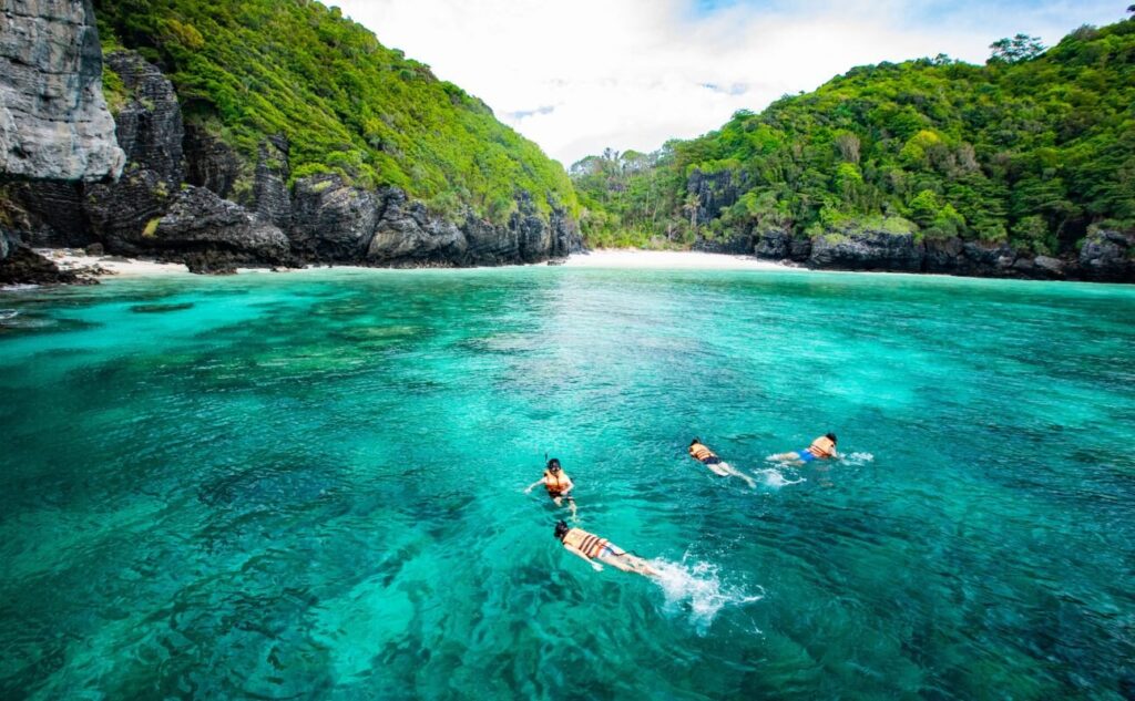 Snorkellers in the emerald water of Pileh Lagoon, Phi Phi Leh