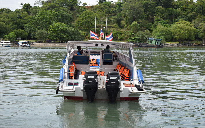 Private twin-engine speedboat waiting offshore for its group