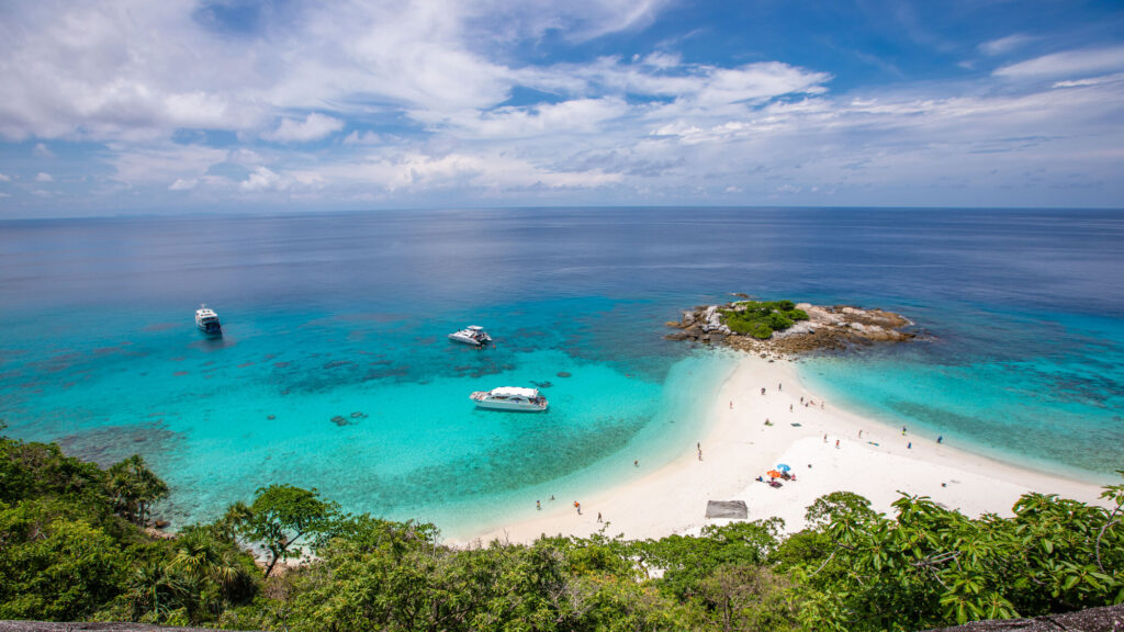Hilltop view over a white sandbar and turquoise bay