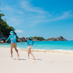Two travellers running along a white sand beach in the Similan Islands