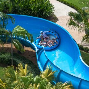 Rider on a tube slide through tropical gardens at Splash Jungle Water Park