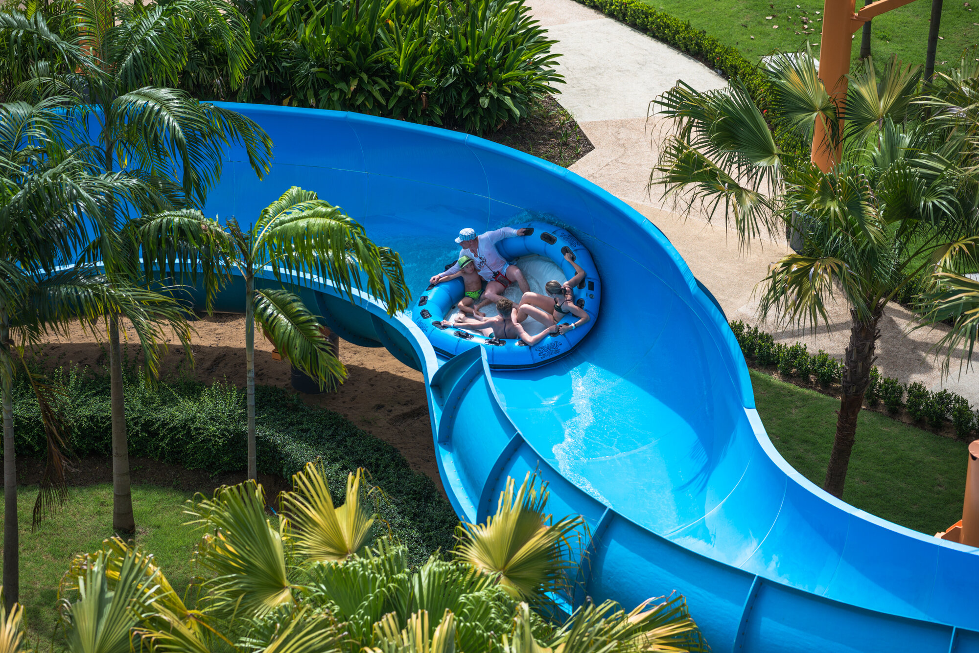 Rider on a tube slide through tropical gardens at Splash Jungle Water Park