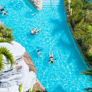 Aerial view of the lazy river lined with palms at Splash Jungle Water Park