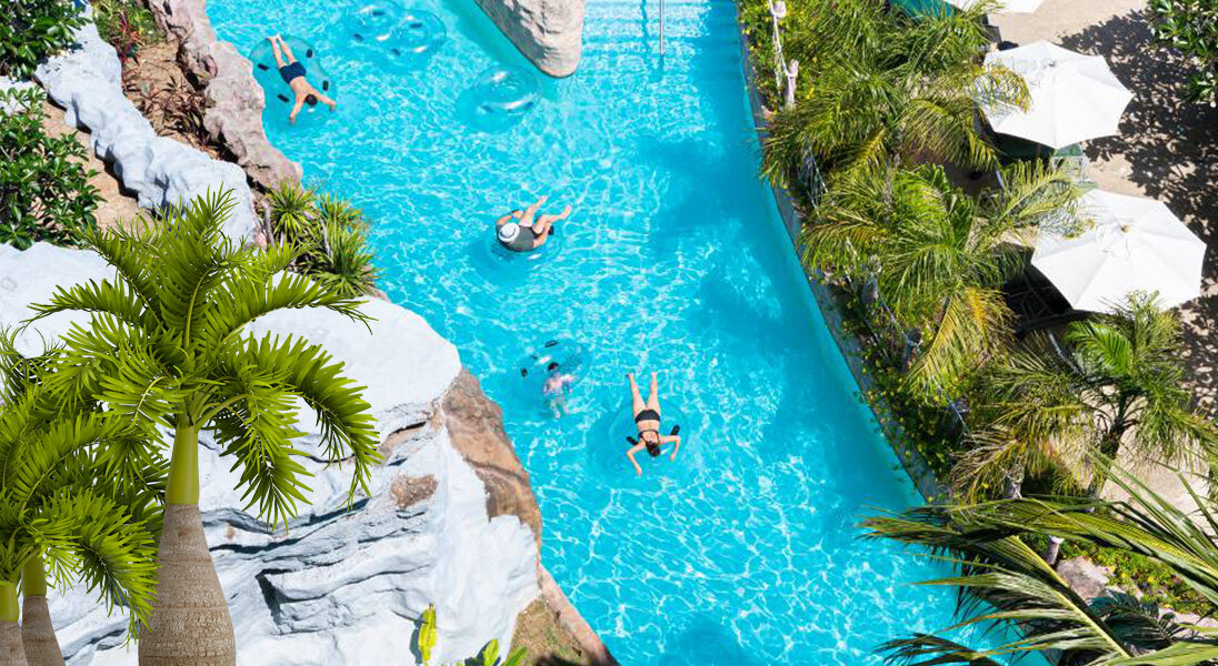 Aerial view of the lazy river lined with palms at Splash Jungle Water Park