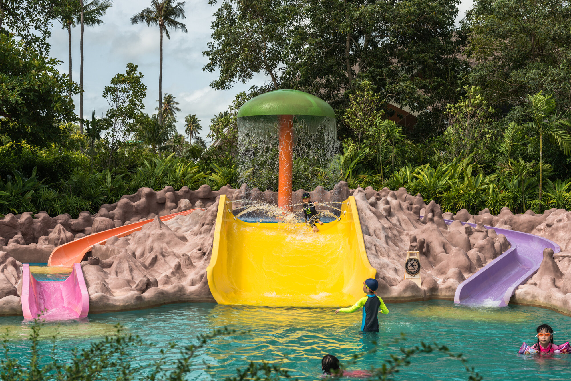 Kids pool with small slides and mushroom fountain at Splash Jungle Water Park