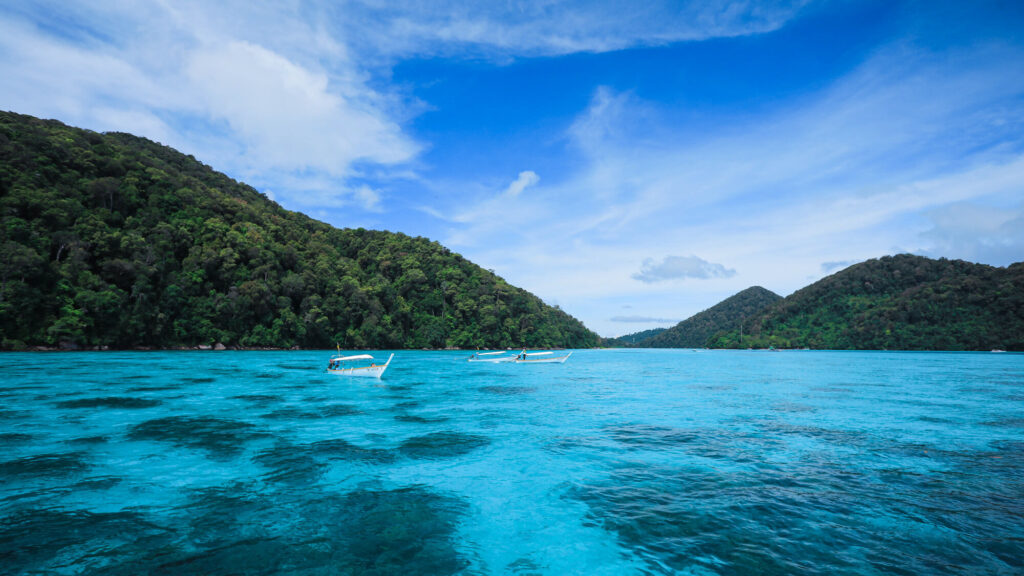 Turquoise water and forested hills in the Surin Islands