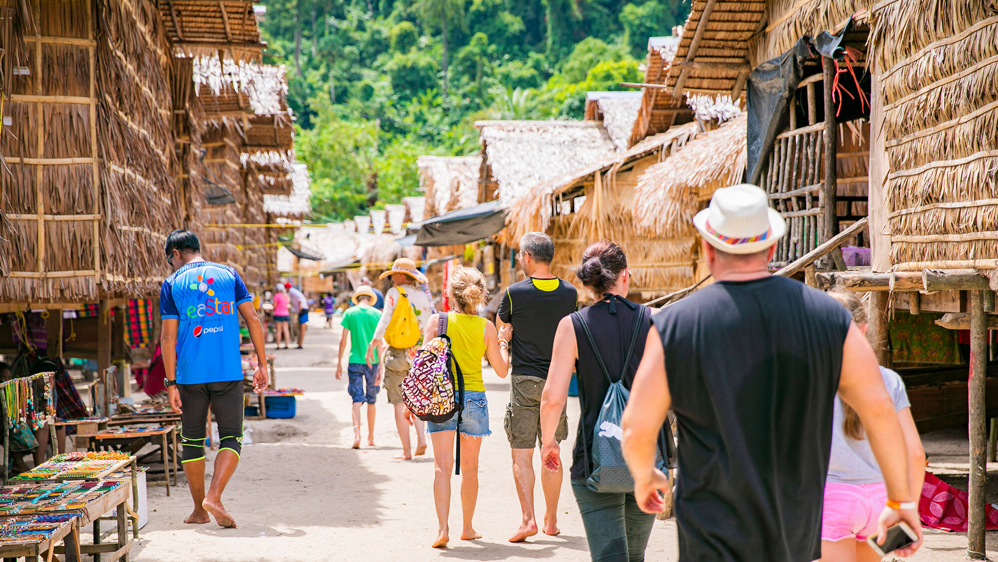 Visitors walking through the Moken sea gypsy village